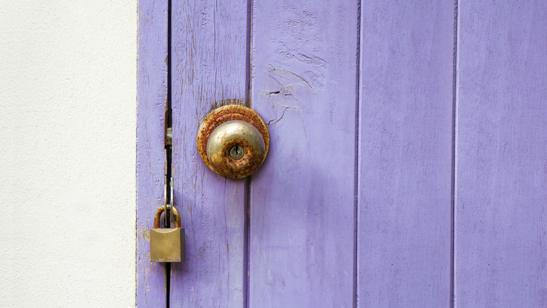 Rusted Doorknob Lock on Purple Door