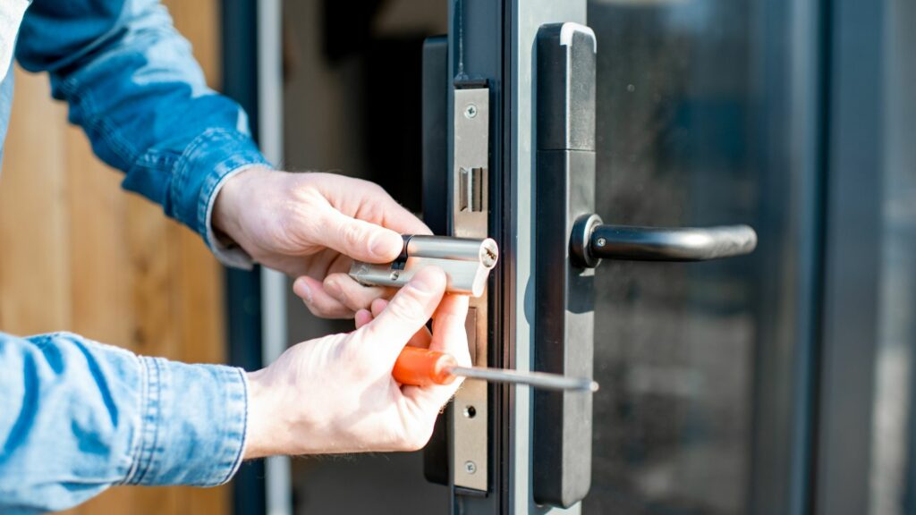 A mobile locksmith repairs a door lock. 